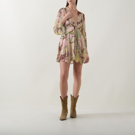 Model wearing Rixo Clove Bianca Abstract Mini Dress in Bianca Abstract Green with tan cowboy boots, plunge neckline and three-quarter sleeves