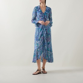 Model wearing Rixo Bianca Abstract Blue silk midi dress with ruffle V-neck and long sleeves, styled with black strappy sandals.