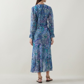 Model wearing Rixo dress in Bianca Abstract Blue paisley-print silk, long sleeves, midi length, back view, styled with brown flat sandals.