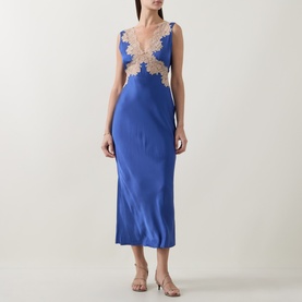 Model wearing Rixo Lysandra Lace Dress in Iris Blue; sleeveless satin midi with nude lace trim at neckline and waist, styled with strappy heels.