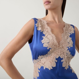 Model wearing Rixo Lysandra Lace Dress in Iris Blue, featuring V-neckline, sleeveless cut and nude tone floral lace panelling on satin fabric.