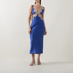Model wearing Rixo Lysandra Lace Dress in Iris Blue; midi-length satin bias-cut with nude lace trim and V-neckline, styled with heeled mules