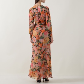 Model wearing Rixo dress in Chelsea Floral Black, long sleeves, V-back neckline, floor-length silhouette, rear view.