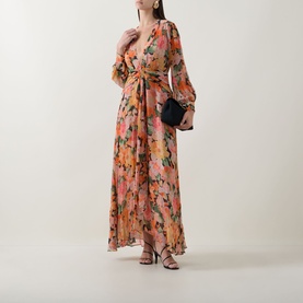 Model wearing Rixo Chelsea Floral Black maxi dress with long sleeves and wrap silhouette, styled with black heeled sandals and clutch bag.