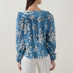 Model wearing Rixo top in Amelia Bouquet Blue floral print, featuring square neckline, puff sleeves and gathered back detail, styled with white