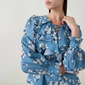 Model wearing Rixo top in Amelia Bouquet Blue floral print with ruffle details, lace-up neckline and balloon sleeves