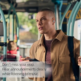 Model wearing Sony Linkbuds True Wireless Earbuds in White, seated on a bus, holding a phone, with a bag strap visible over shoulder.