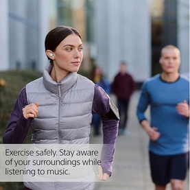 Model wearing Sony Linkbuds True Wireless Earbuds in White, jogging outdoors in a grey gilet and purple long-sleeve top.