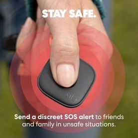 Hand pressing a small black Tile personal safety device, with red pulse graphic and Stay Safe text overlay