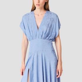 Model wearing a pale blue V-neck midi dress with short sleeves, gathered waist detail, and subtle jacquard pattern with side split