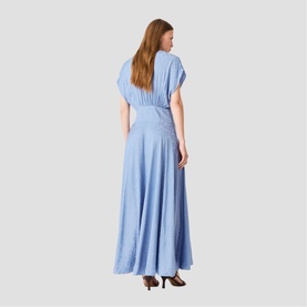Model wearing light blue maxi dress with short sleeves, gathered waist detail, and flared skirt, styled with dark heeled mules, rear view