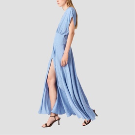 Model wearing light blue maxi dress with flutter sleeves, wrap-style bodice, and high side split, styled with black strappy heeled sandals