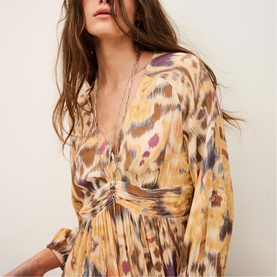 Model wearing Bash yellow abstract animal print dress with deep V-neckline, twisted waist detail and long sleeves