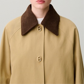 Model wearing Claude Pierlot coat in clear beige with brown suede-effect collar and gold oval buttons, styled over white top