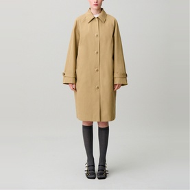 Model wearing Claude Pierlot clear beige long coat with button front, styled with grey ribbed socks and black sandals