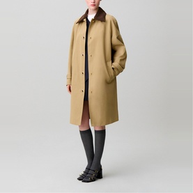 Model wearing Claude Pierlot oversized beige trench coat with brown collar, styled with dark mini dress, grey socks and black loafers