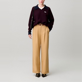 Model wearing Claude Pierlot black V-neck polo jumper, styled with camel wide-leg trousers, brown belt, and black loafers