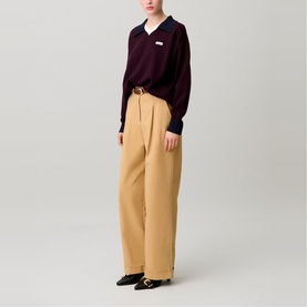 Model wearing Claude Pierlot black V-neck knit top with contrast collar, styled with camel wide-leg trousers and black loafers