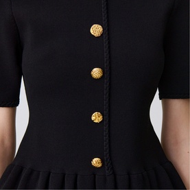 Claude Pierlot black short-sleeve dress with gold embossed buttons and contrast braid trim detail, pleated hem visible.