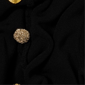 Claude Pierlot black knit fabric close-up with ornate gold embossed buttons detail.