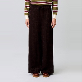 Model wearing Claude Pierlot dark brown wide-leg corduroy trousers with drawstring waist, styled with a striped knit top.
