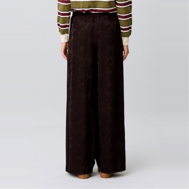 Model wearing Claude Pierlot dark brown wide-leg jacquard trousers, styled with a striped knit top.