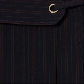 Claude Pierlot black pinstripe wrap skirt detail showing belted waistband with gold eyelet hardware and contrast stripe pattern