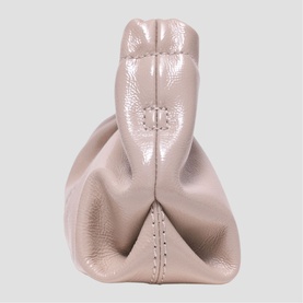 Maje bag in mastic beige pebbled leather, viewed from above, showing structured top handle and contrast stitch detailing.