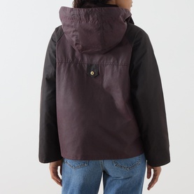 Model wearing Barbour wax cotton jacket in Bordeaux and black colourblock with hood, back view, styled with blue jeans