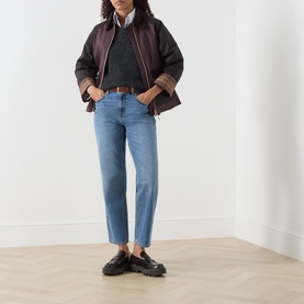 Model wearing Barbour wax cotton jacket in Rustic/Bordeaux/Muted, styled with blue straight-leg jeans, brown belt and black loafers.