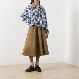 Model wearing Barbour Gingham Navy jacket, styled with tan midi skirt, white socks and black loafers