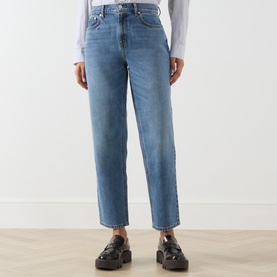 Model wearing Barbour mid blue straight-leg jeans in 100% cotton, styled with a white shirt and black chunky loafers.