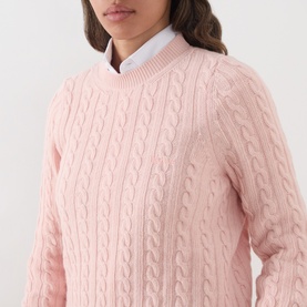 Model wearing Barbour Ashdown Cable-Knit Sweater in Pink Blush, featuring cable-knit pattern and round neck, styled with a white collared shirt