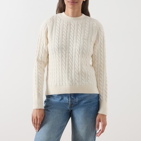 Model wearing Barbour Ashdown Cable-Knit Sweater in ecru with round neck and cable-knit pattern, styled with blue jeans.
