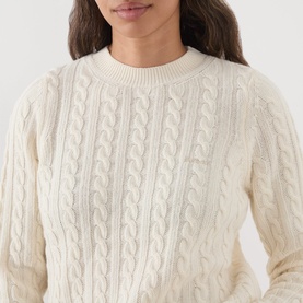 Model wearing Barbour Ashdown Cable-Knit Sweater in Ecru, featuring cable-knit pattern and round neck, relaxed fit