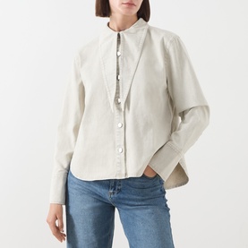 Model wearing Barbour Harleigh Tie-Neck Denim Shirt in Washed Birch, with tie-neck collar, dropped shoulders, styled with blue jeans