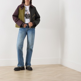Model wearing Barbour Mariana Dog T-Shirt in white with colourblock jacket, light blue straight-leg jeans and black loafers.