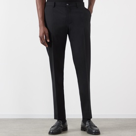 Model wearing Dolce & Gabbana black tailored trousers with a slim fit, styled with black leather loafers.