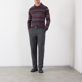 Model wearing Dolce & Gabbana blue wool striped polo shirt, styled with grey trousers and dark leather shoes.