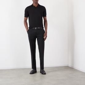 Model wearing Dolce & Gabbana black silk polo shirt, styled with black tailored trousers, belt and leather loafers.