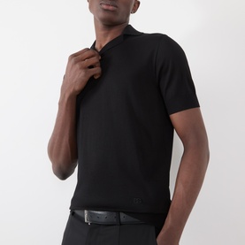 Model wearing Dolce & Gabbana black silk polo, styled with a black leather belt. Short sleeves, ribbed collar.