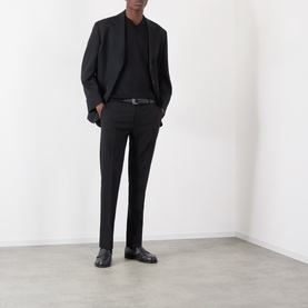 Model wearing Dolce & Gabbana black silk polo, styled with black blazer, tailored trousers, belt and leather shoes.