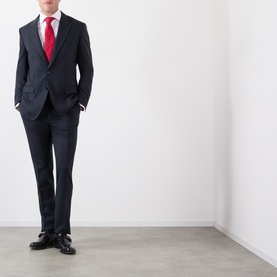 Model wearing Dolce & Gabbana black wool slim-fit suit, styled with white shirt, red tie and black lace-up Oxford shoes.