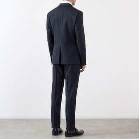 Model wearing Dolce & Gabbana black wool suit, rear view, single-breasted jacket with tailored trousers and black dress shoes.