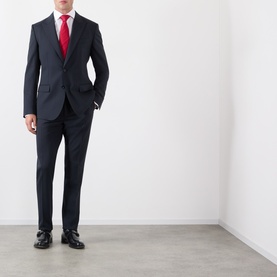Model wearing Dolce & Gabbana black wool suit with red tie, white shirt and black leather loafers