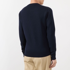 Model wearing Dolce & Gabbana dark blue 100% virgin wool sweatshirt, back view, styled with beige trousers.