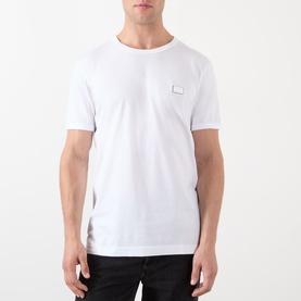 Model wearing Dolce & Gabbana Logo Badge T-Shirt in Optical White with round neck, short sleeves, and chest logo badge.