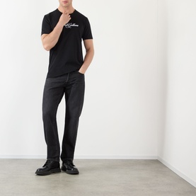 Model wearing Dolce & Gabbana Script Logo T-Shirt in black with dark jeans and black leather shoes.
