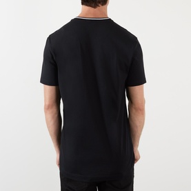 Model wearing Dolce & Gabbana black cotton T-shirt, rear view, with white and grey tipping detail at crew neck collar.