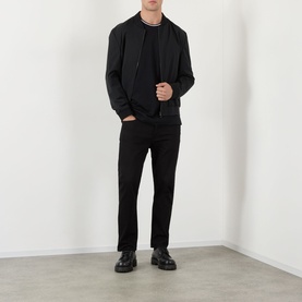 Model wearing Dolce & Gabbana black cotton T-shirt, styled with black bomber jacket, slim black jeans and black leather shoes.